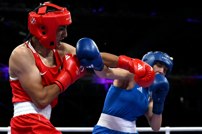 Algerian male boxer Imane Khelif (in red) punches Italy's Angela Carini in the women's 66kg preliminaries round of 16 boxing match during the Paris 2024 Olympic Games at the North Paris Arena, in Villepinte on August 1, 2024.