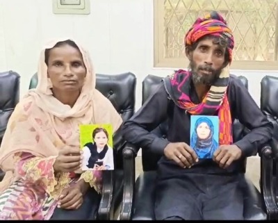 Sumera Bibi and her husband with portraits of their forcibly converted and married daughters who were kidnapped in Kasur District, Pakistan, on July 23, 2024.