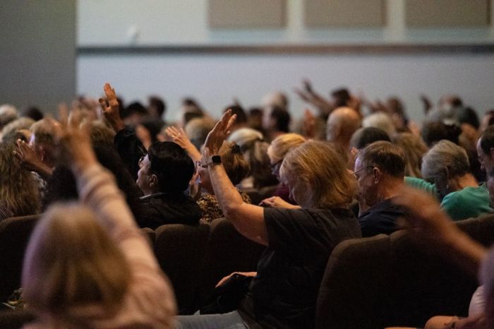 Attendees raise their hands in prayer during the 'Unmasking Gender Ideology II' event at Burke Community Church in Burke, Virginia, on Oct. 6, 2024.