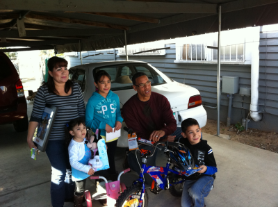 The boy, who chose to give his sisters new bikes instead of himself with his raffle wins, receives his own bike from Pastor Miles McPherson from Rock Church in San Diego, California.