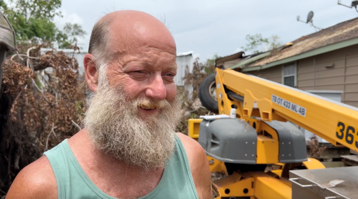 Homeowner Ken Anderson stands outside his home as he is assisted by volunteers from Texans on Mission in the aftermath of Hurricane Beryl in Jones Creek, Texas.